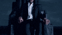 a man in a suit is sitting in a chair