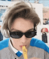 a person wearing sunglasses and headphones is blowing a yellow object