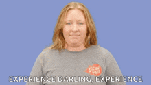 a woman wearing a sticker giant t-shirt says experience darling experience