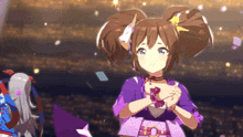 a girl in a purple dress stands in front of a crowd with her hands folded