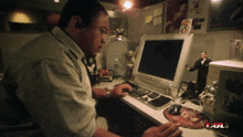 a man sits at a desk in front of a computer with the word bul on the bottom left