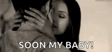 a black and white photo of a man and woman kissing with the words `` soon my baby '' written above them .