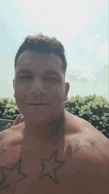 a man without a shirt has three stars on his chest