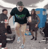 a man in a black shirt is jumping in a room with a viggle.ai watermark
