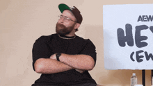 a man sitting in front of a sign that says hey