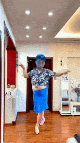 a man with blue hair and a blue skirt is dancing in a room .