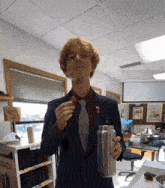 a man in a suit and tie holds a bottle and a cookie