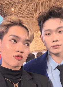 two young men are posing for a picture and one has a necklace that says ' sd ' on it