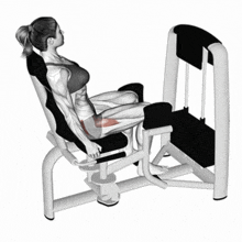 a woman is sitting on a machine with her legs extended