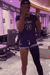 a woman in a purple lsu jersey is dancing