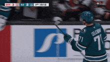 a hockey player with the number 71 on his jersey is holding a hockey stick