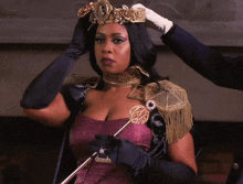 a woman in a purple dress and black gloves has a gold crown on her head