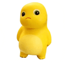 a yellow toy with big eyes and a sad look on his face