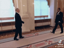 two men in suits are walking down a hallway with a tiktok watermark