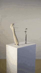a statue of a hand on a white block