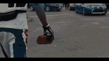 a person holding a brick in their hand while walking down the street