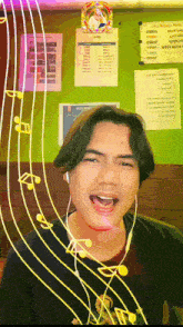 a man wearing ear buds is singing in front of a green wall with a menu hanging from it