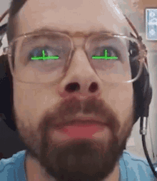 a man with a beard and glasses is wearing headphones and has green eyes .