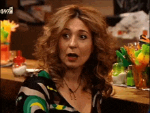 a woman sitting at a bar with a w7 logo on the bottom right