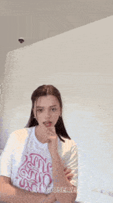 a woman is wearing a white t-shirt with the word hooduserie on it .