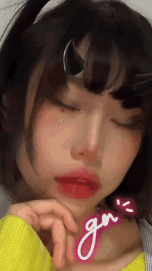 a close up of a girl 's face with the letters gn written on her neck