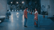 a man and a woman are standing next to each other on a patio .