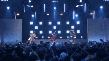 a group of women are dancing on a stage in front of a crowd