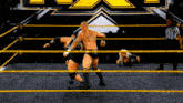 two wrestlers are in a ring with a referee watching