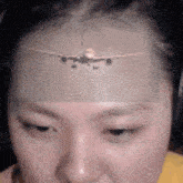a close up of a woman 's face with a picture of an airplane on her forehead