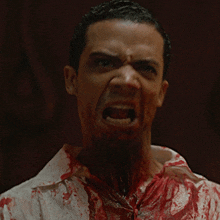 a man with blood on his shirt is making a face