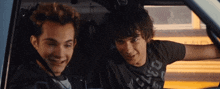 two boys are sitting in a car and one has a shirt that says chicago