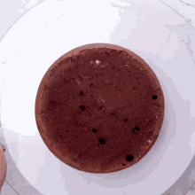 a chocolate cake is sitting on a white surface