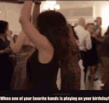 a woman is dancing with her arms in the air at a party