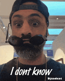 a man with a beard is wearing sunglasses and a hat and says i dont know