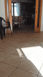 a chair in a room with a sliding glass door leading to a kitchen