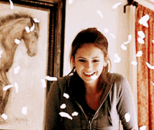 elena gilbert feathers floating around her in a spell the vampires diaries