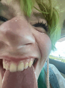 a close up of a person 's face with their tongue hanging out