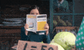 a girl is reading a book with chinese writing