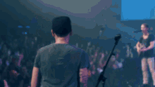 a group of people are singing into microphones in a dark room