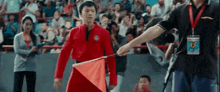 a man in a red jacket is holding a red flag .
