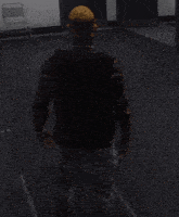 a man in a black shirt and jeans is standing in a dark hallway in a video game .