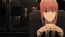 a woman with pink hair is sitting in a chair with her hands folded in front of a man in a suit and tie
