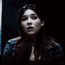 a close up of a woman 's face with a shocked look on her face