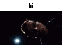 a man is laying down in a dark room with a light shining on him .