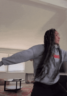 a woman wearing a grey sweatshirt with the word nike on the front
