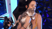 a woman is holding a cat in her arms
