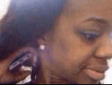 a woman is talking on a cell phone and making a face .