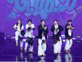 a group of young men are dancing on a stage in front of a purple background that says ' g ' on it