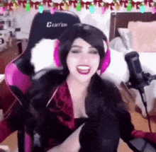 a woman wearing headphones and a wig is sitting in a pink chair .