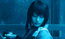 a woman in a blue kimono is holding a bowl